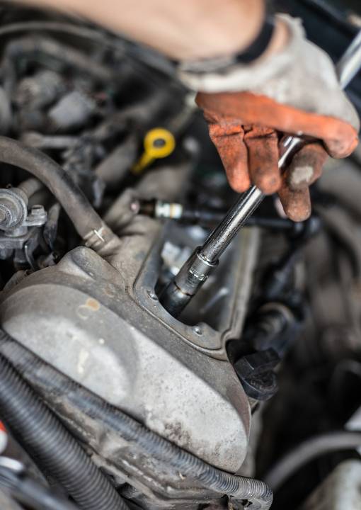 Mechanic changing broken car spark plugs
